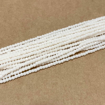 2 mm. Perles verre rondes à facettes. Blanc rosé. Fil 180 p