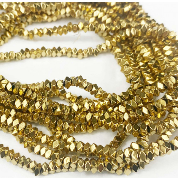 Plaqué or 18 K. Fil de perles cubes à facettes, hématite synth. 3*3 mm.