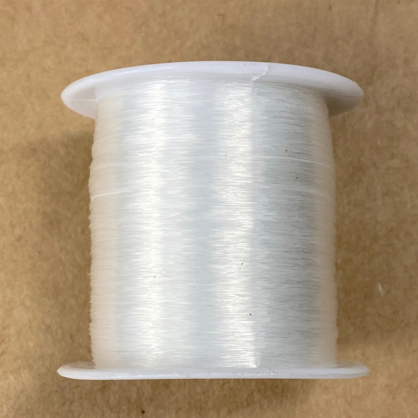 Bobine de 130 mètres de fil de nylon, dit fil de pêche, transparent. Diam.  0,2 mm