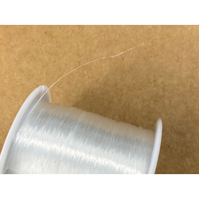 Bobine de 130 mètres de fil de nylon, dit fil de pêche, transparent. Diam.  0,2 mm